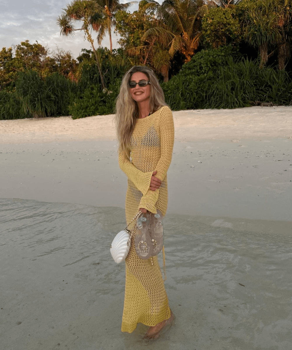 Emili Sindlev - vestido longo amarelo tramado - look da virada - verão - mulher loira de óculos em pé na praia - https://stealthelook.com.br