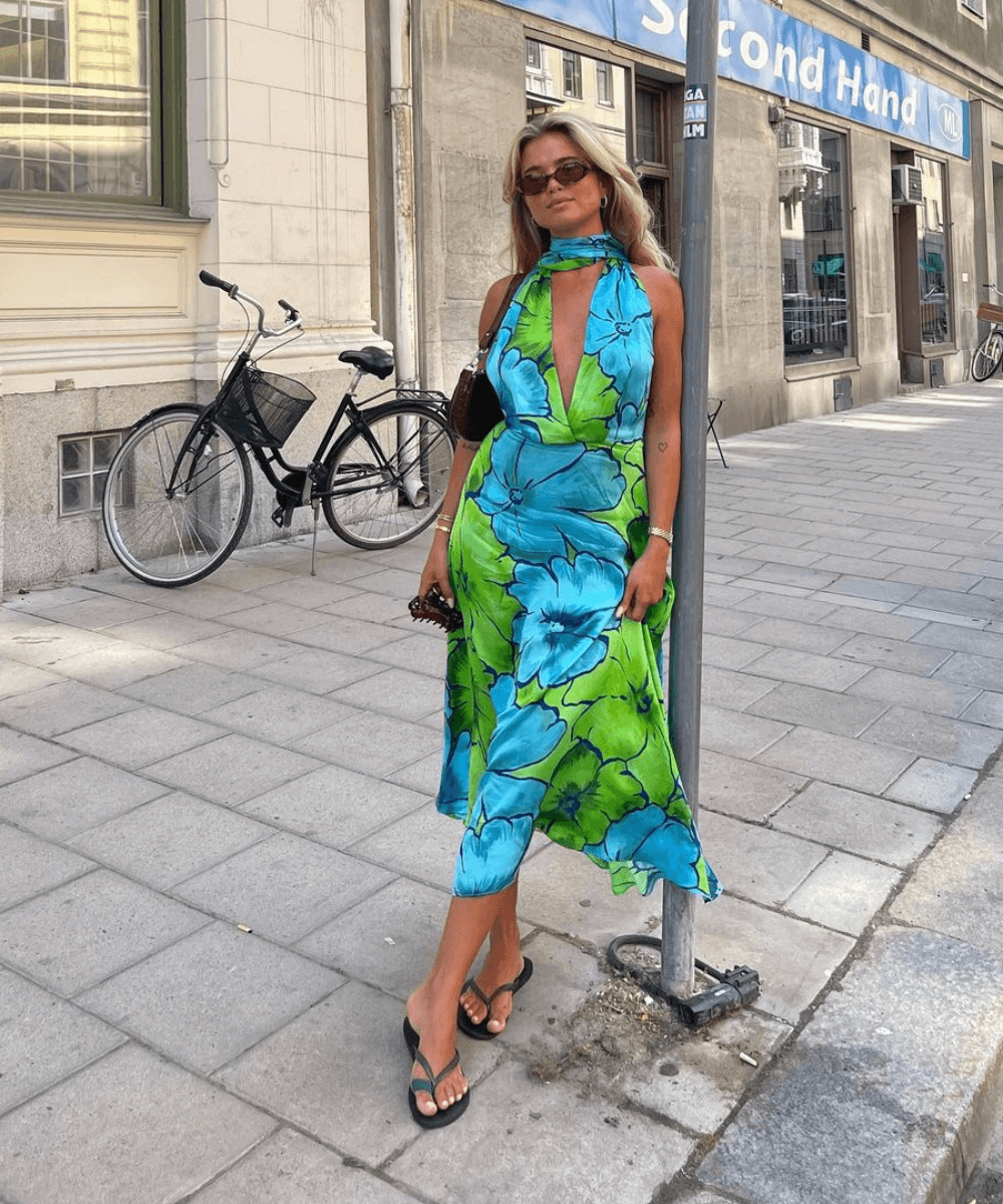 Matilda Djerf - vestido verde e azul floral midi - look da virada - verão - mulher loira em pé na rua usando óculos de sol - https://stealthelook.com.br