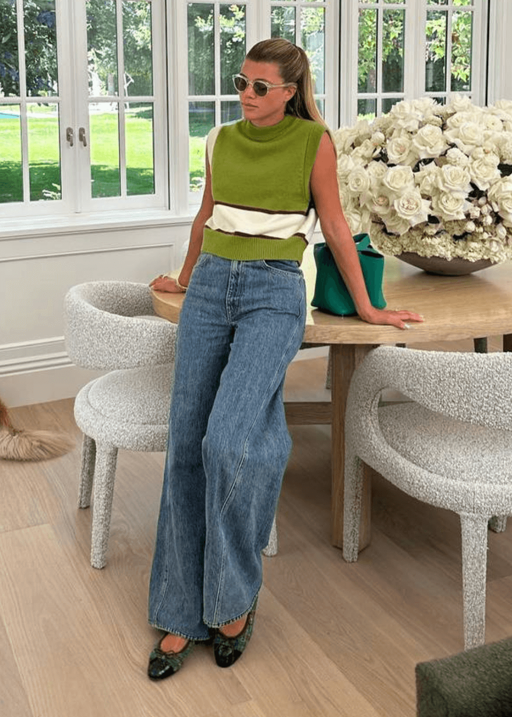Sofia Richie - calça jeans, blusa de tricot verde e sapatilha - looks de celebridades - outono - mulher loira dentro de uma sala apoiada em um piano - https://stealthelook.com.br