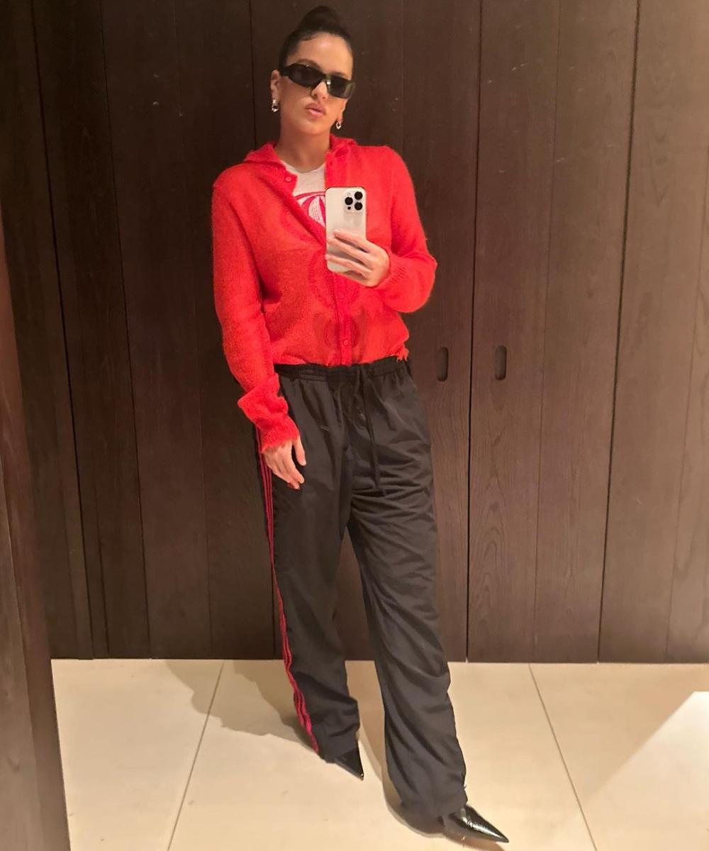 Rosalía - calça preta e suéter vermelho - sportswear - inverno - mulher em pé tirando foto no espelho usando óculos de sol - https://stealthelook.com.br