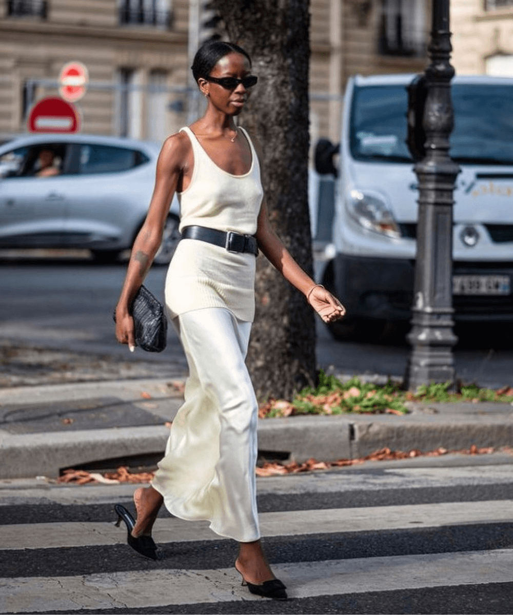 Sylvie Mus - saia midi branca, tamanco preto e blusa regata branca - sapato elegante - verão - mulher negra de óculos andando na rua - https://stealthelook.com.br