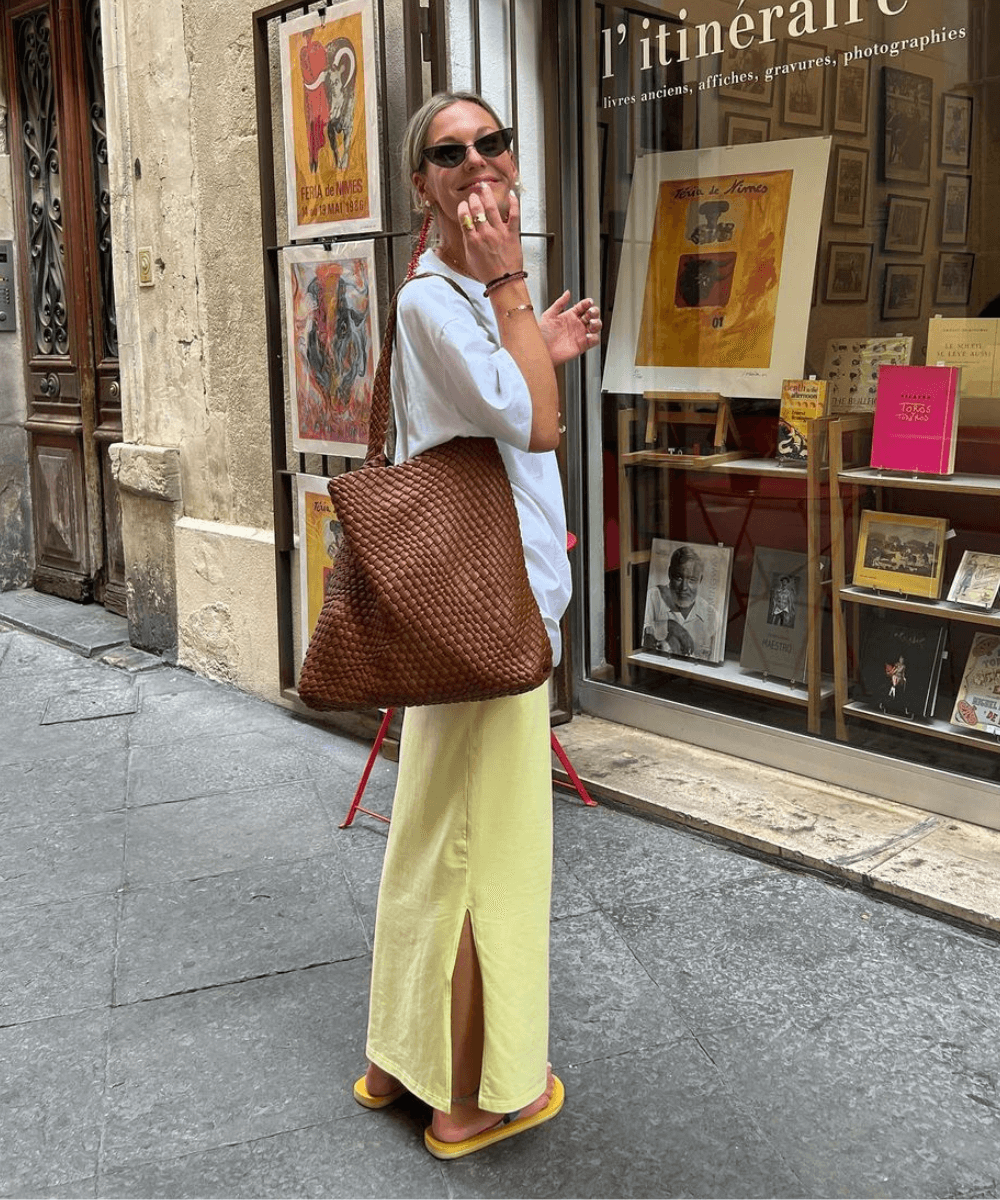 @tinvcb - saia midi acetinada amarela, t-shirt branca oversized e chinelo  - looks fresquinhos - verão - mulher loira em pé na rua - https://stealthelook.com.br