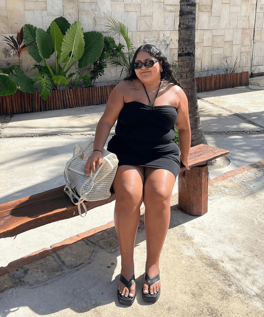@stephmnavarro - vestido curto preto e chinelo de plataforma - looks fresquinhos - verão - menina de cabelo enrolado castanho sentada um banco na rua usando óculos de sol - https://stealthelook.com.br
