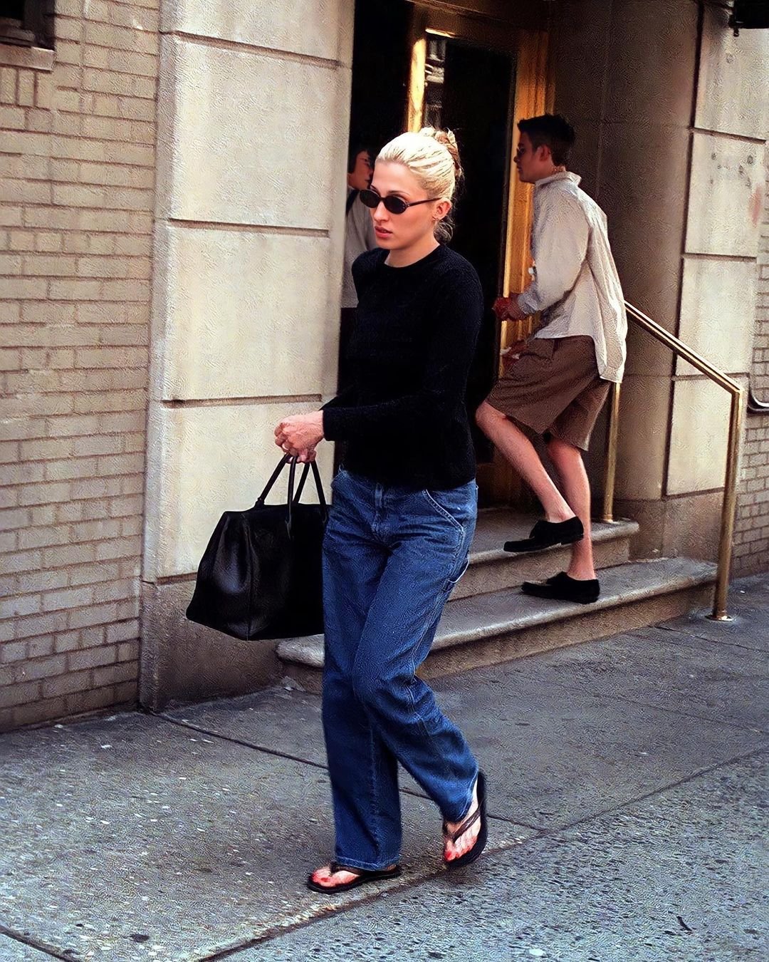 Carolyn Bessette-Kennedy - sueter preto calça jeans havaianas maxi bolsa - maxi bolsa - primavera outono - rua - https://stealthelook.com.br