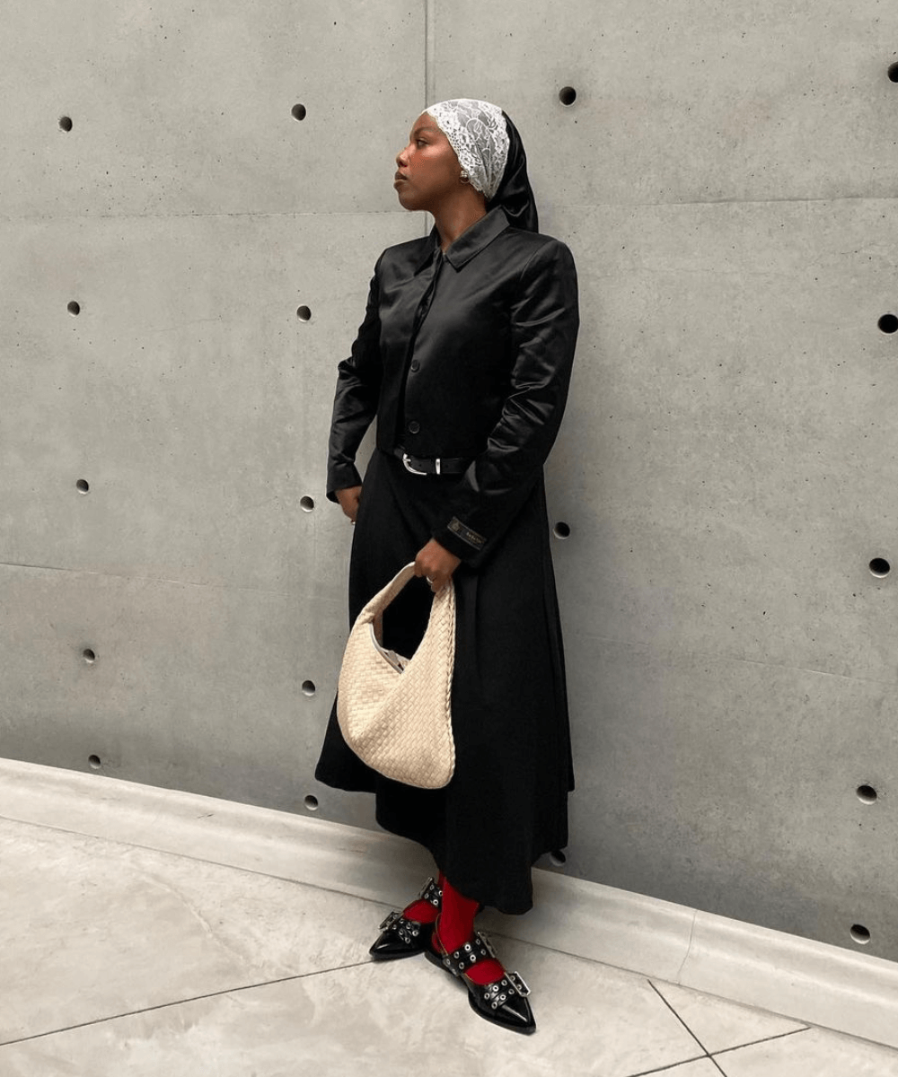 @blackmaroccan - saia midi preta, tricot preto, meias vermelhas e mocassins - inverno 2024 - outono - mulher negra em pé na rua - https://stealthelook.com.br