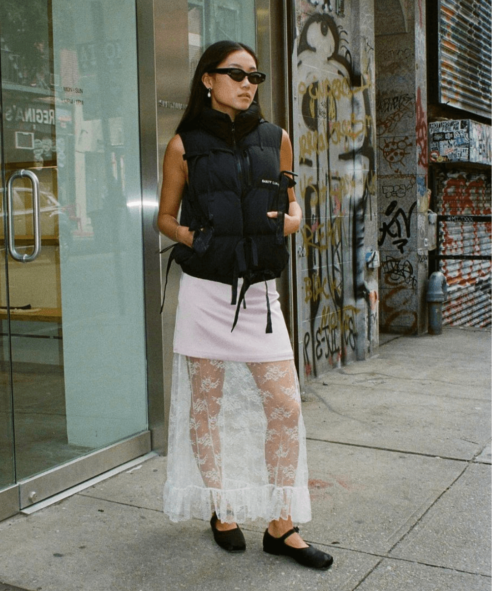 @vivian.yrl - saia midi rosa, t-shirt cinza e sapatilha preta bailarina - tendências de moda - primavera - mulher asiática de óculos andando na rua - https://stealthelook.com.br