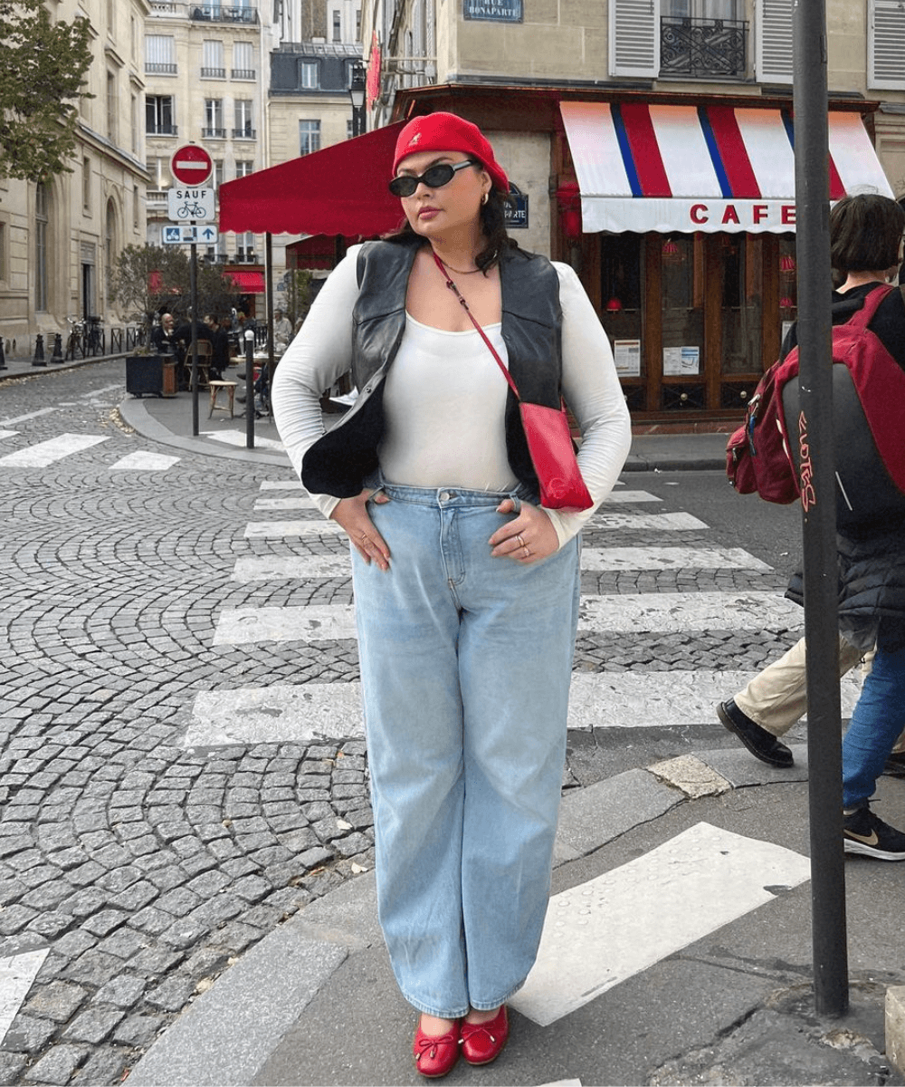 Francesca Perks - calça jeans, blusa branca, colete preto, boina e sapatilha vermelha - sapato vermelho - outono - mulher em pé na rua usando óculos de sol e boina - https://stealthelook.com.br