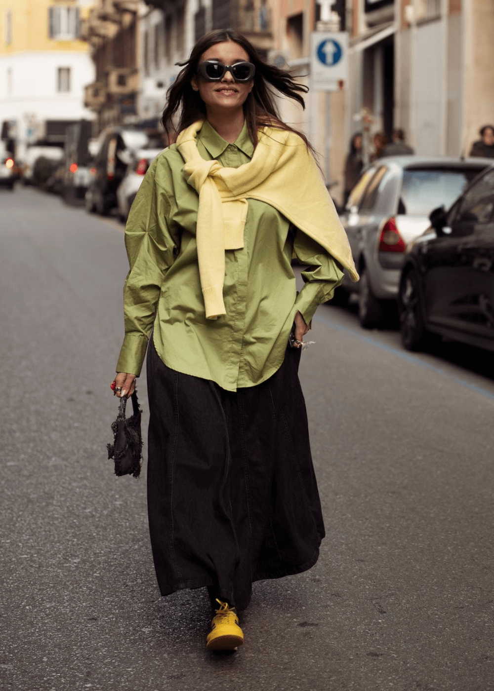 Street Style de Milão - saia longa preta, camisa verde overiszed, tênis amarelo e óculos - street style de Milão - inverno - mulher de óculos andando na rua - https://stealthelook.com.br