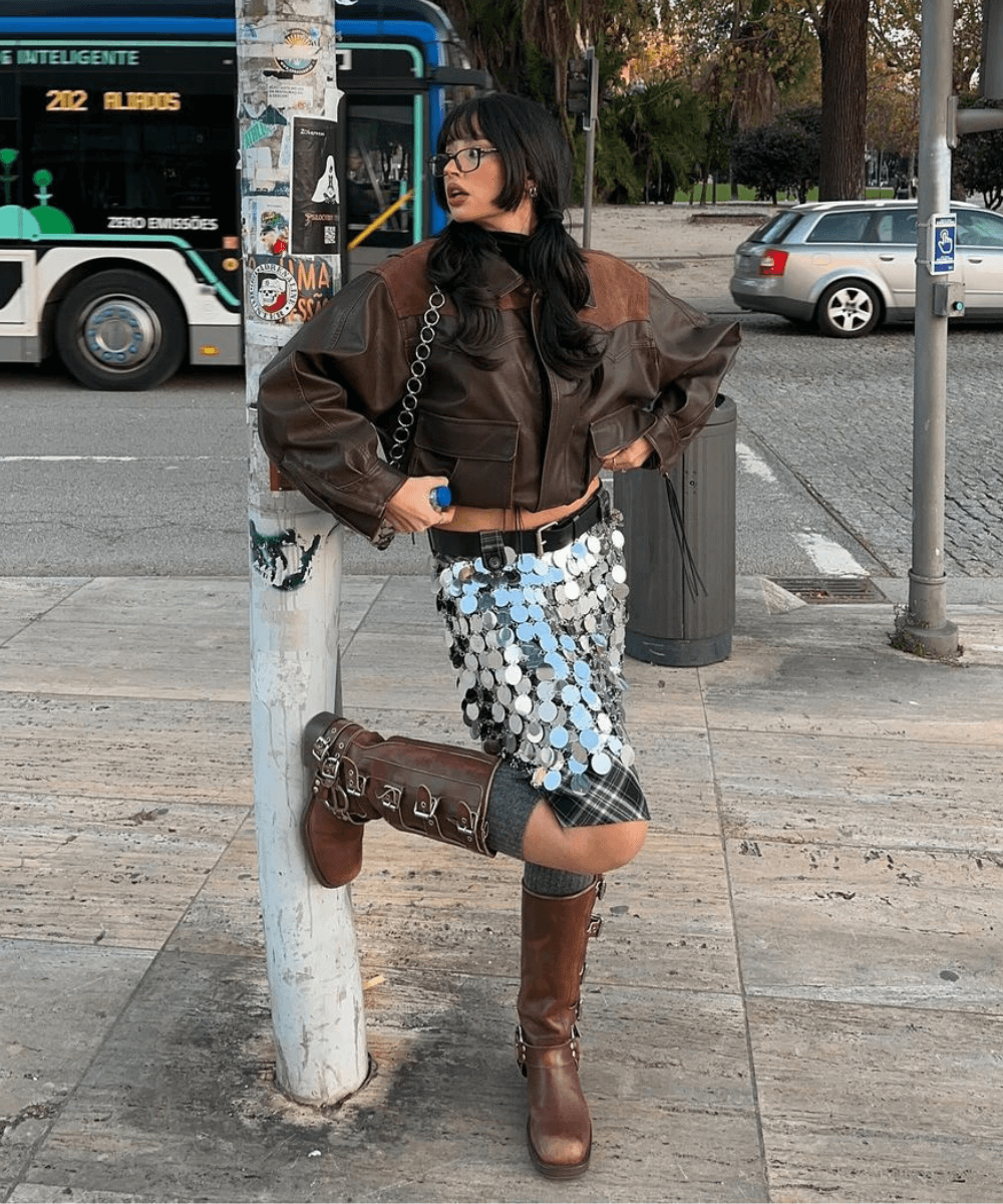 Ines Silva | @irisloveunicorns - saia de paetê, biker boots e jaqueta biker marrom - tendências do inverno 2024 - inverno - mulher em pé na rua usando óculos de sol - https://stealthelook.com.br