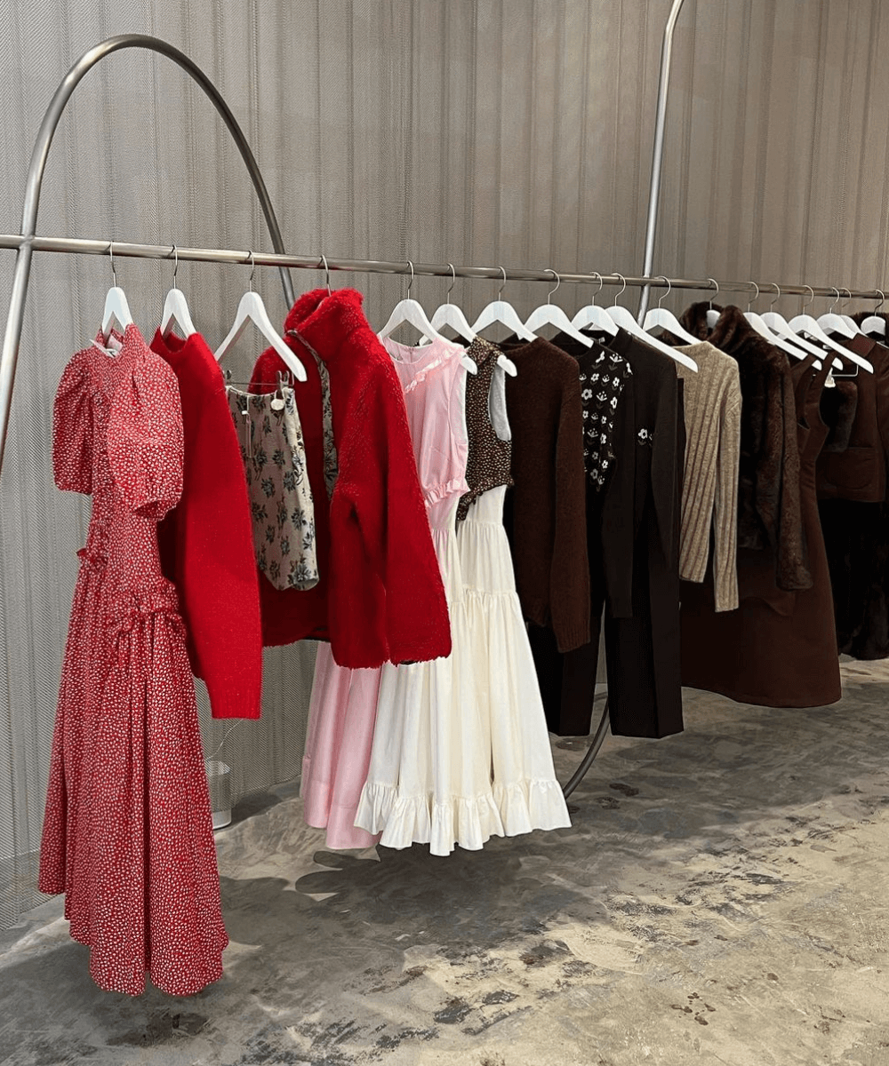 Sandy Liang - roupas diversas - Sandy Liang - outono - a foto mostra a área de uma loja com várias roupas coloridas penduradas nas araras - https://stealthelook.com.br