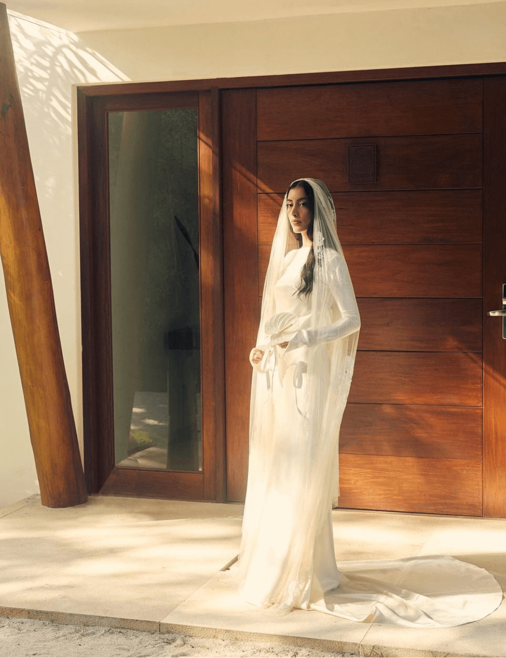 Maju Trindade - vestido de noiva - vestido de noiva da Maju Trindade - verão - mulher vestida de noiva com véu sob o rosto em pé no sol - https://stealthelook.com.br