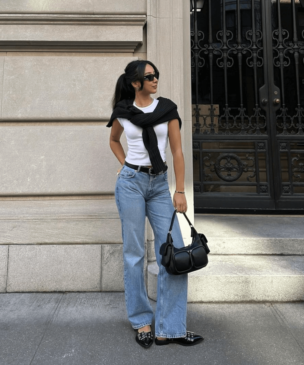 Kristy Who - jeans, blusa branca, tricot preto amarrado nos ombros, sapatilha e bolsa preta - armário cápsula - verão - mulher asiática de óculos em pé na rua olhando para o lado - https://stealthelook.com.br