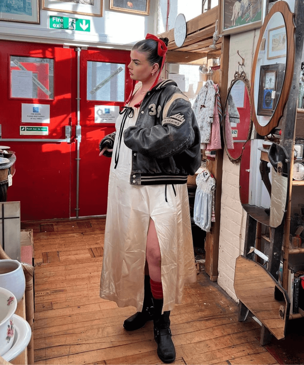 Francesca Perks - vestido longo, jaqueta de couro e botas de fivela - biker boots - outono - mulher em pé em uma loja - https://stealthelook.com.br