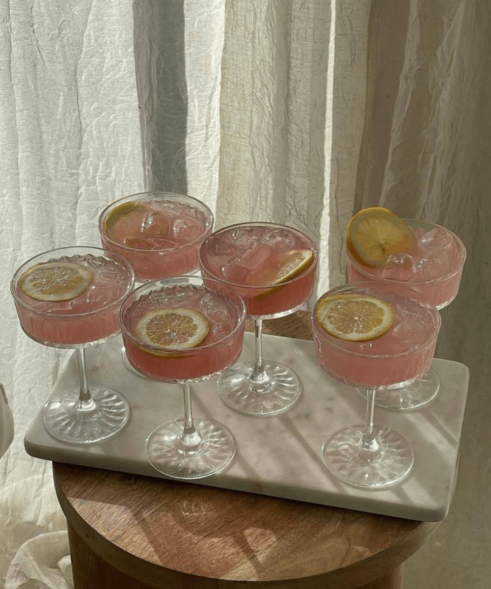 Drink sem Álcool - N/A - Drink sem álcool - verão - a foto mostra seis tacinhas de vidro com um drink rosa e rodelas de limão por cima - https://stealthelook.com.br