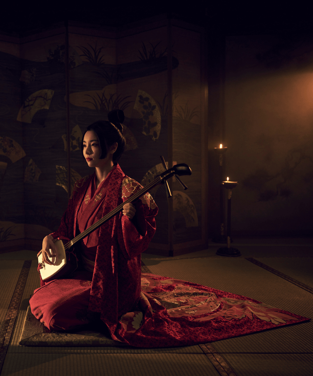 Xógum: A Gloriosa Saga do Japão - kimono vermelho - Xógum - verão - mulher asiática sentada em uma sala usando kimono cinza - https://stealthelook.com.br