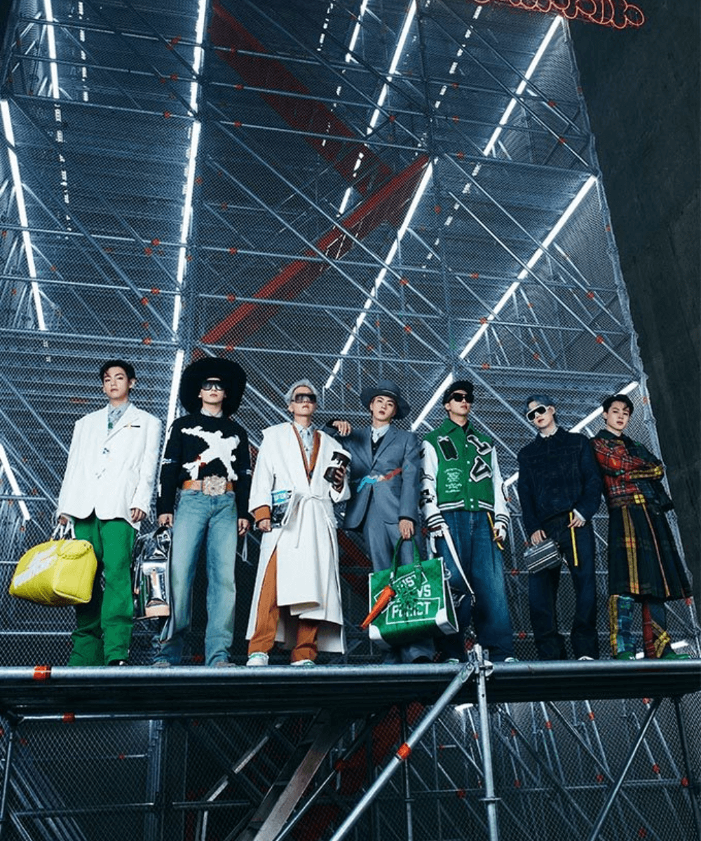 BTS - roupas diversas - K-pop - inverno - Seis homens asiáticos posando para a foto segurando bolsas diversas - https://stealthelook.com.br