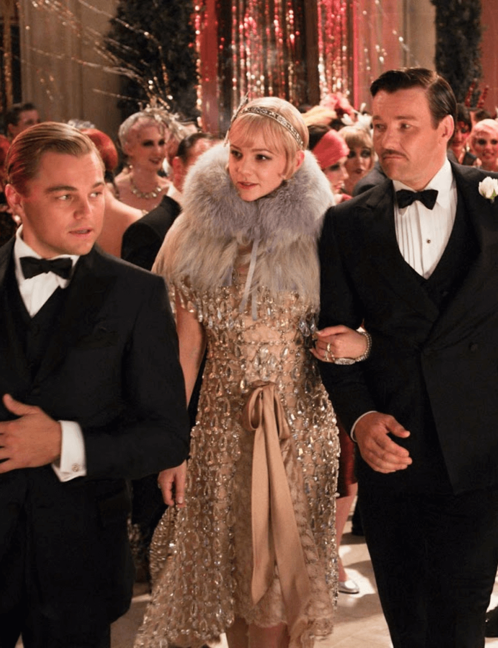 O Grande Gatsby - roupas diversas - figurinos mais emblemáticos - inverno - a foto mostra dois homens e uma mulher andando por um salão - https://stealthelook.com.br