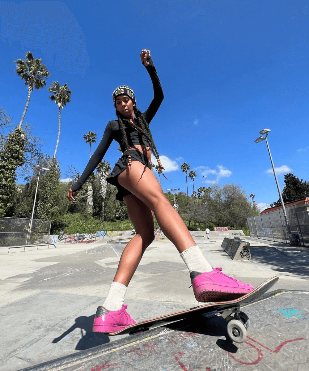 Briana King - shorts preto, blusa preta de manga longa e tênis rosa - Moda e Skate - verão - mulher negra de tranças andando de skate - https://stealthelook.com.br