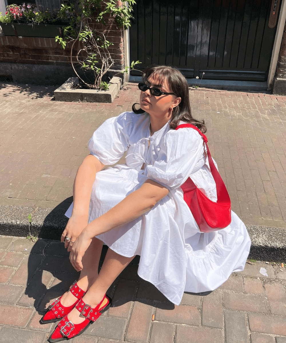 Francesca Perks - vestido branco midi bufante e bolsa vermelha - bolsas tendência - verão - mulher loira de óculos sentada na calçada - https://stealthelook.com.br
