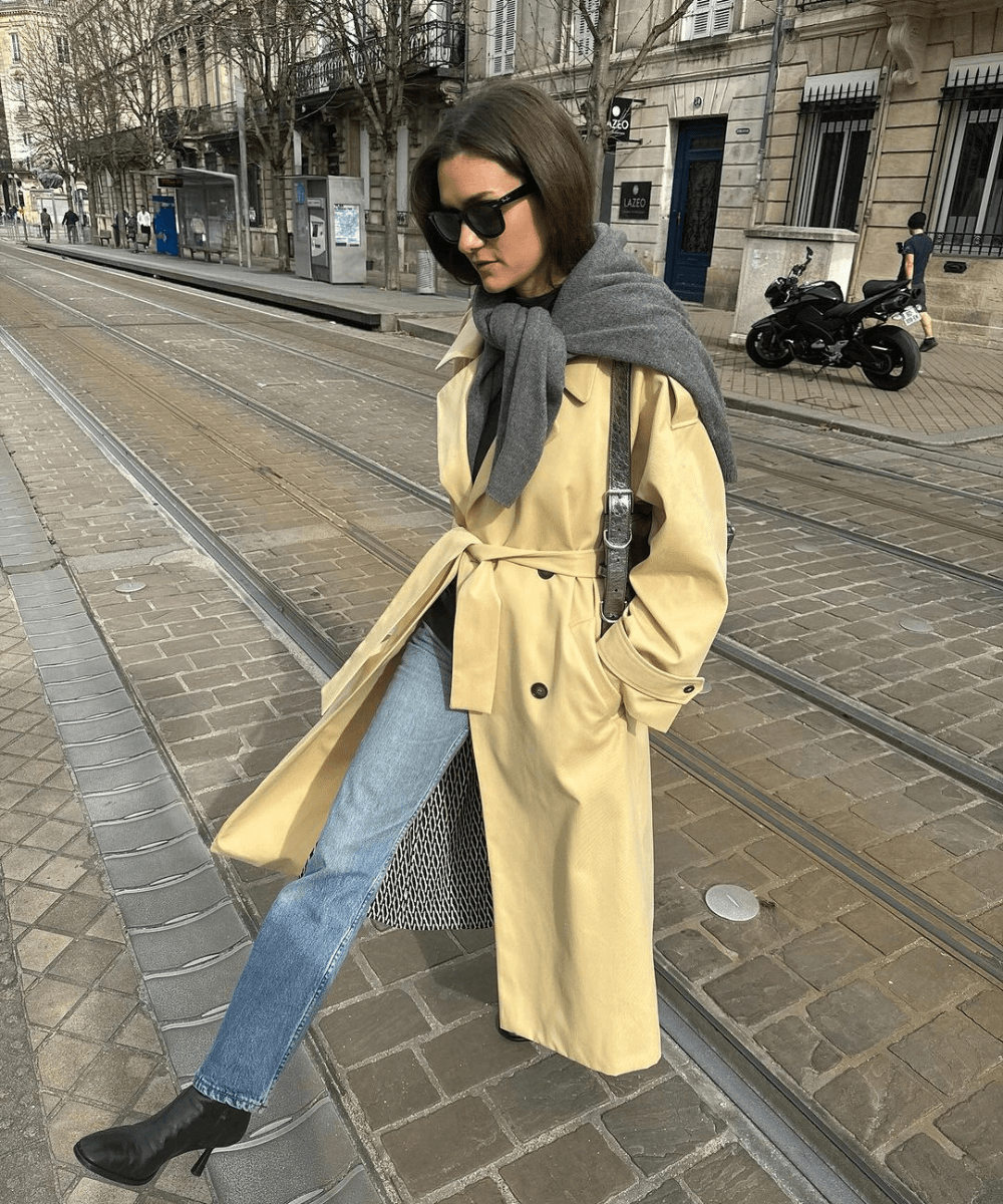 Adenorah | @annelauremais - calça jeans, bota preta, casaco longo amarelo e óculos de sol - looks de frio - inverno - mulher em pé na rua usando óculos de sol - https://stealthelook.com.br