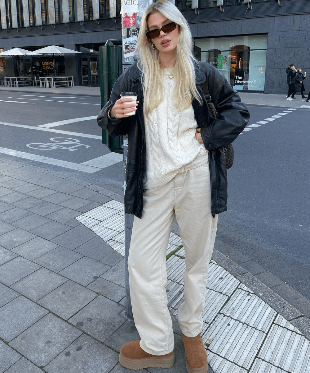 @linda.sza - calça jeans, tricot off white e botas ugg - inverno 2024 - inverno - mulher loira andando na rua usando óculos de sol - https://stealthelook.com.br