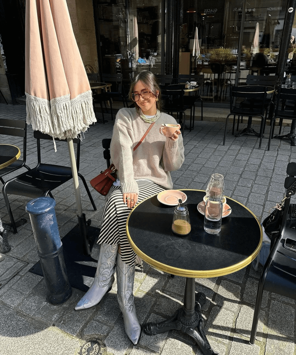 @florettenacer - saia longa, tricot e bota western - inverno 2024 - inverno - mulher sentada em um café na rua - https://stealthelook.com.br