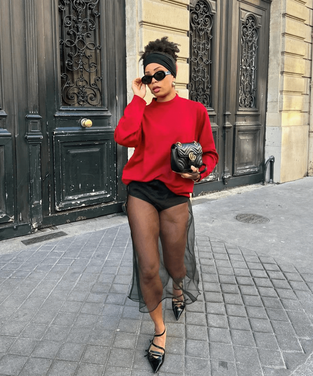 Ellie Delphine - saia preta transparente, tricot vermelho e salto preto - looks transparentes - outono - mulher negra em pé na rua usando óculos de sol - https://stealthelook.com.br