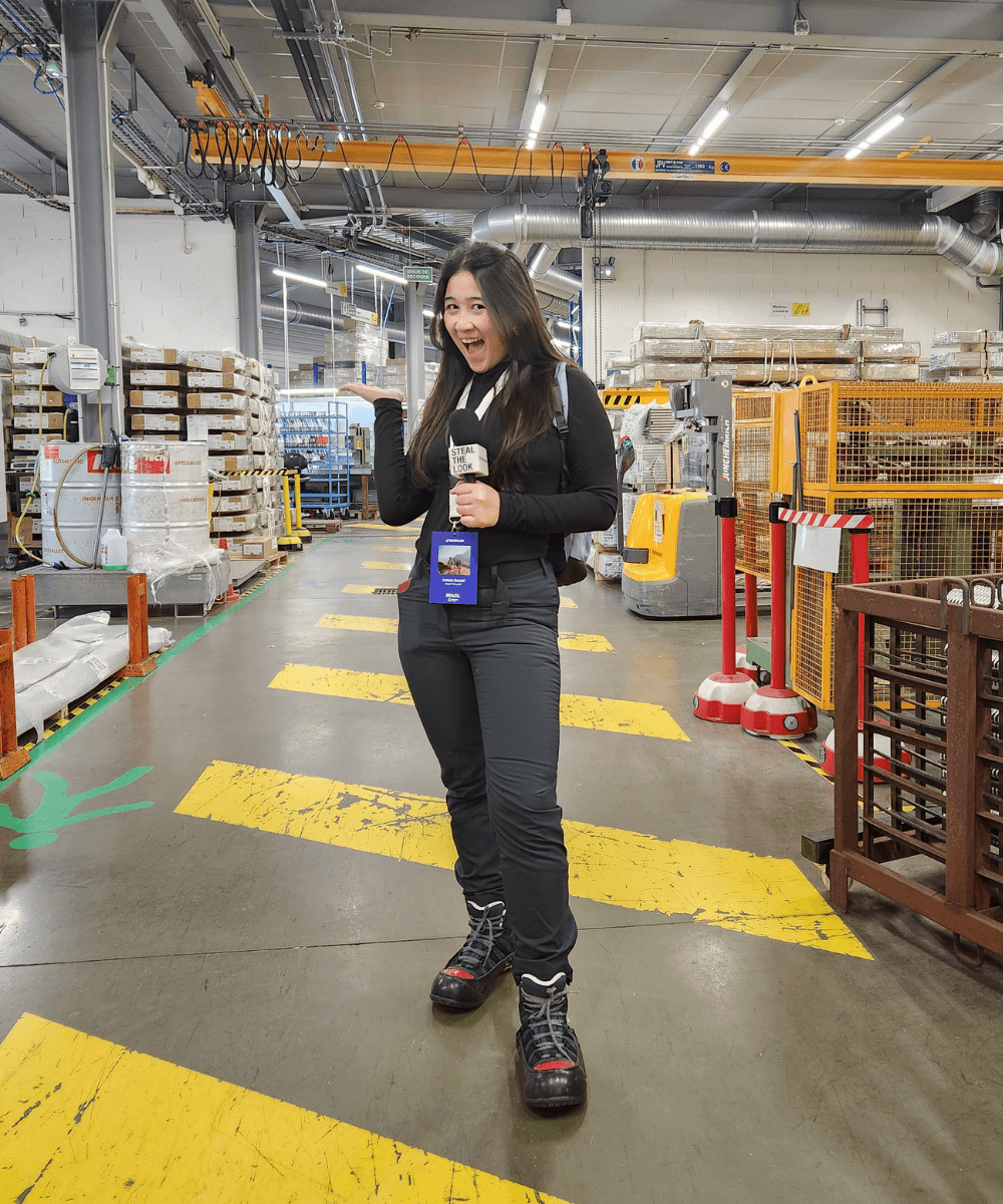 Iza Suzuki - roupa de neve - neve - inverno - mulher asiática segurando um microfone em pé em uma fábrica - https://stealthelook.com.br