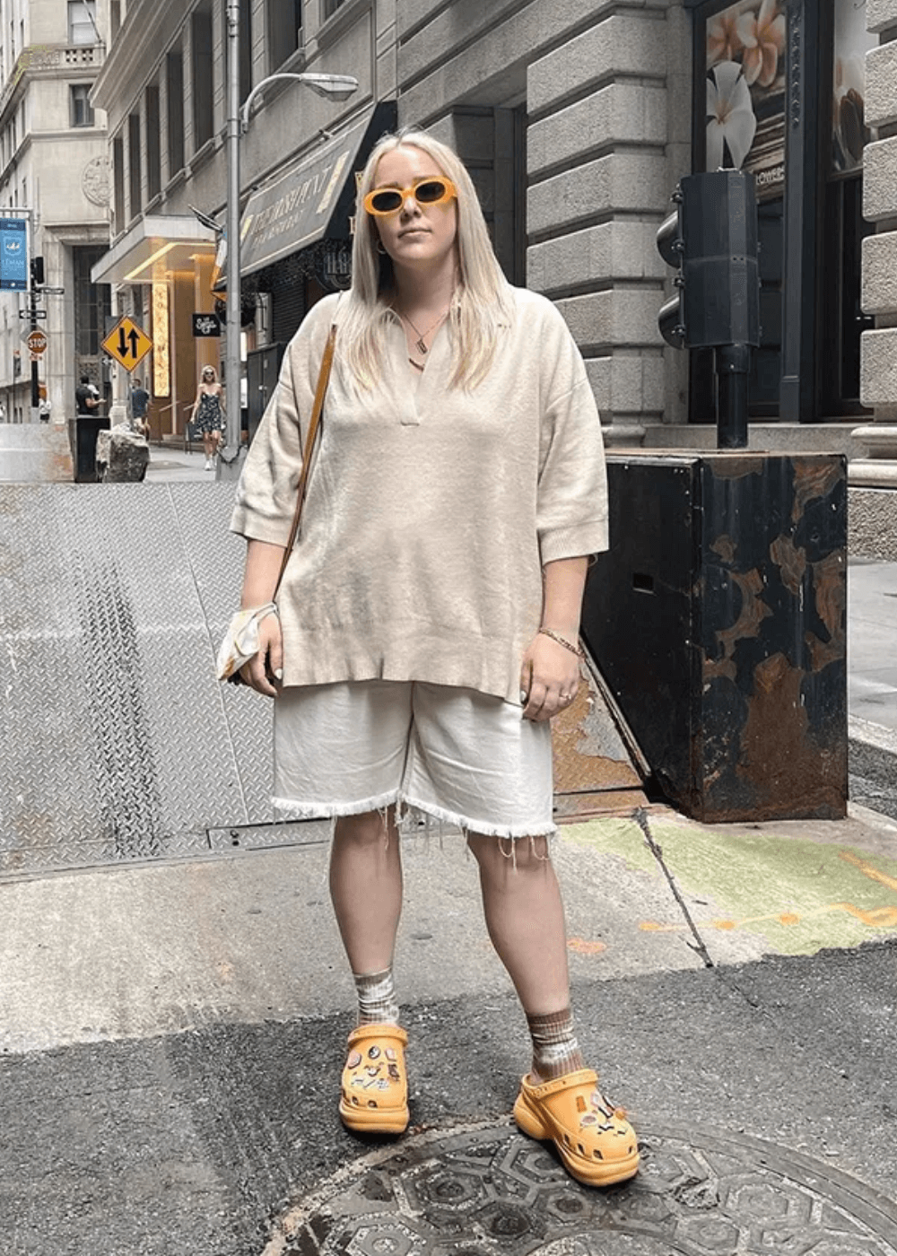 N/A - bermuda, t-shirt oversized bege e crocs - sapato personalizado - verão - mulher loira de óculos em pé na rua - https://stealthelook.com.br