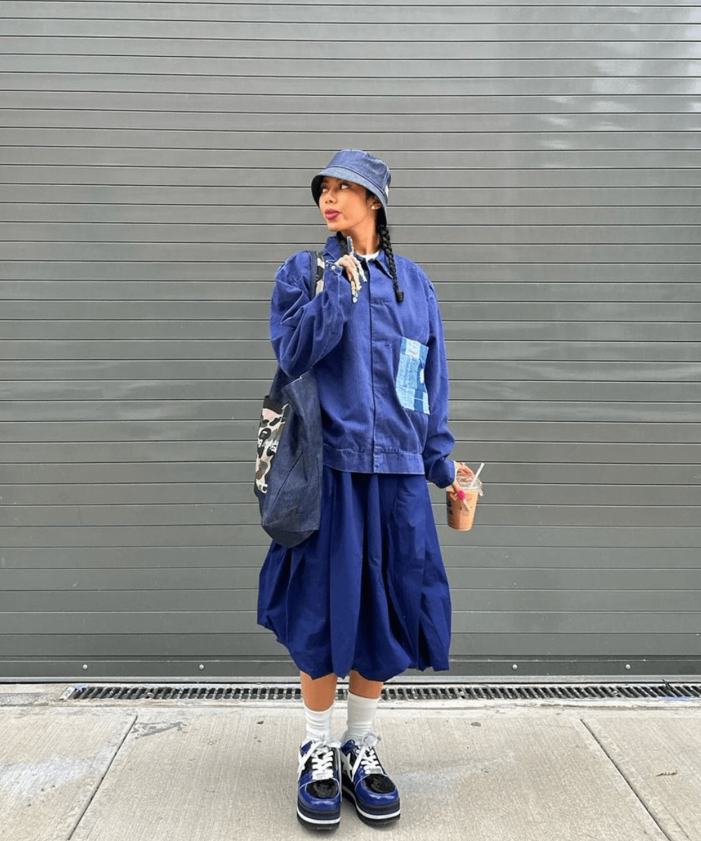 @wuzg00d - saia midi balonê azul, camiseta oversizede tênis - balonê - outono - mulher negra em pé na rua usando boné - https://stealthelook.com.br