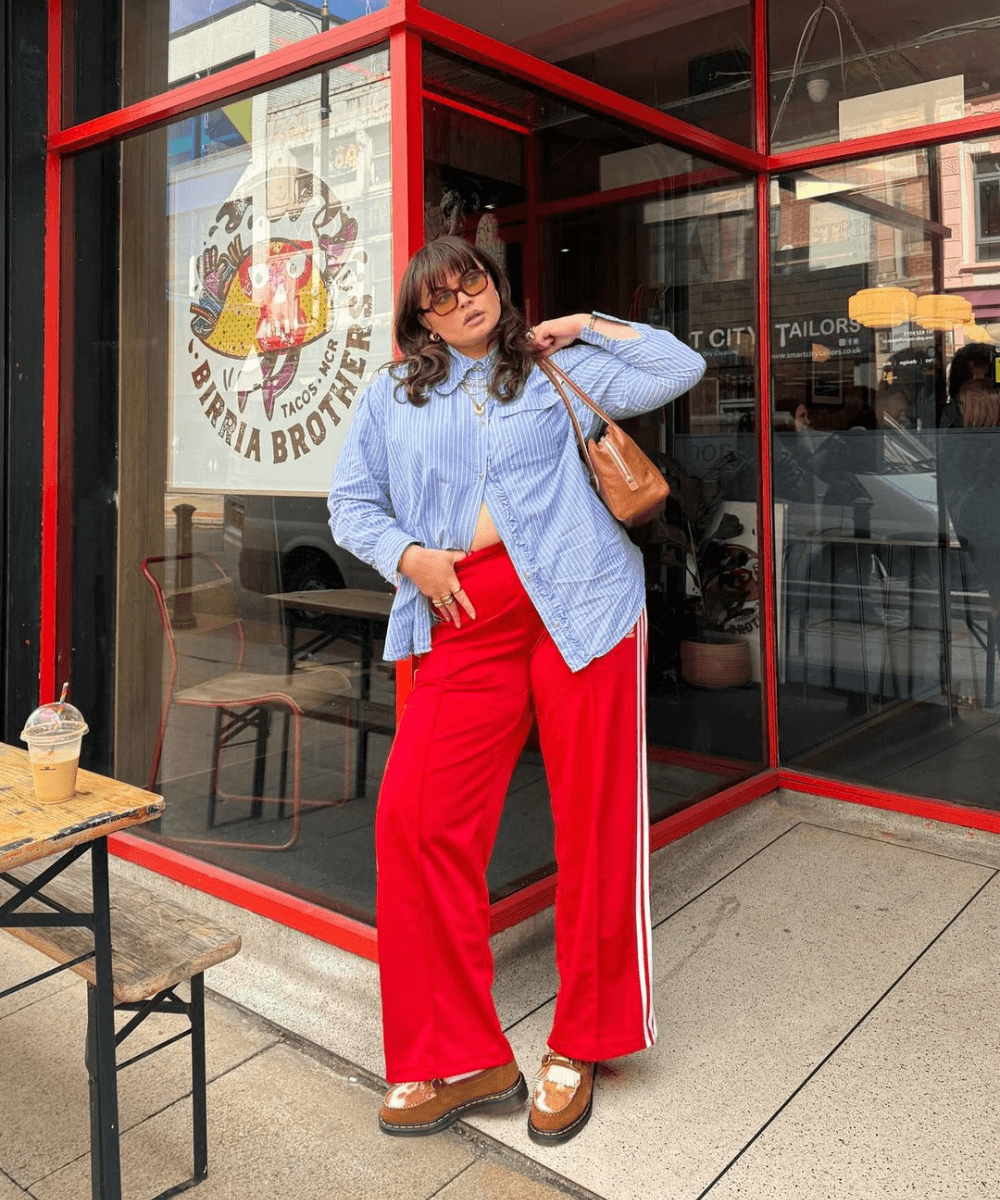 Francesca Perks - calça adidas vermelha, camisa social azul e mocassim marrom - Adidas - outono - mulher loira andando na rua usando óculos de sol - https://stealthelook.com.br