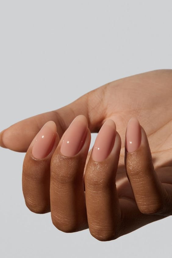 Unhas em gel amendoada com esmalte nude em formato amendoado, tendência elegante e minimalista no mundo da moda. A cor neutra e a forma suave são ideais para um visual sofisticado, combinando com diferentes estilos e ocasiões.