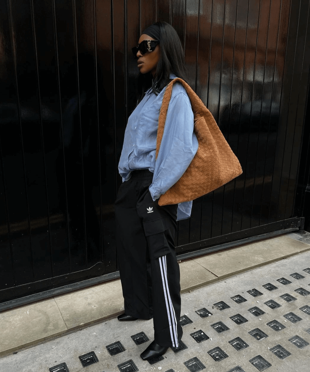 @georgia_3.0 - calça adidas preta, camisa jeans e botas - calça esportiva - inverno - mulher negra em pé na rua usando óculos de sol - https://stealthelook.com.br