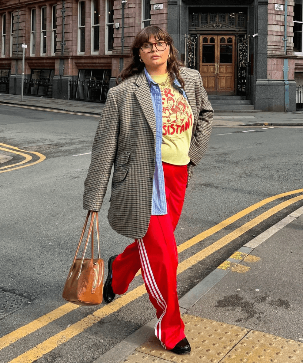 Francesca Perks - calça adidas vermelha, t-shirt e blazer xadrez - calça esportiva - inverno - mulher andando na rua usando óculos de sol - https://stealthelook.com.br