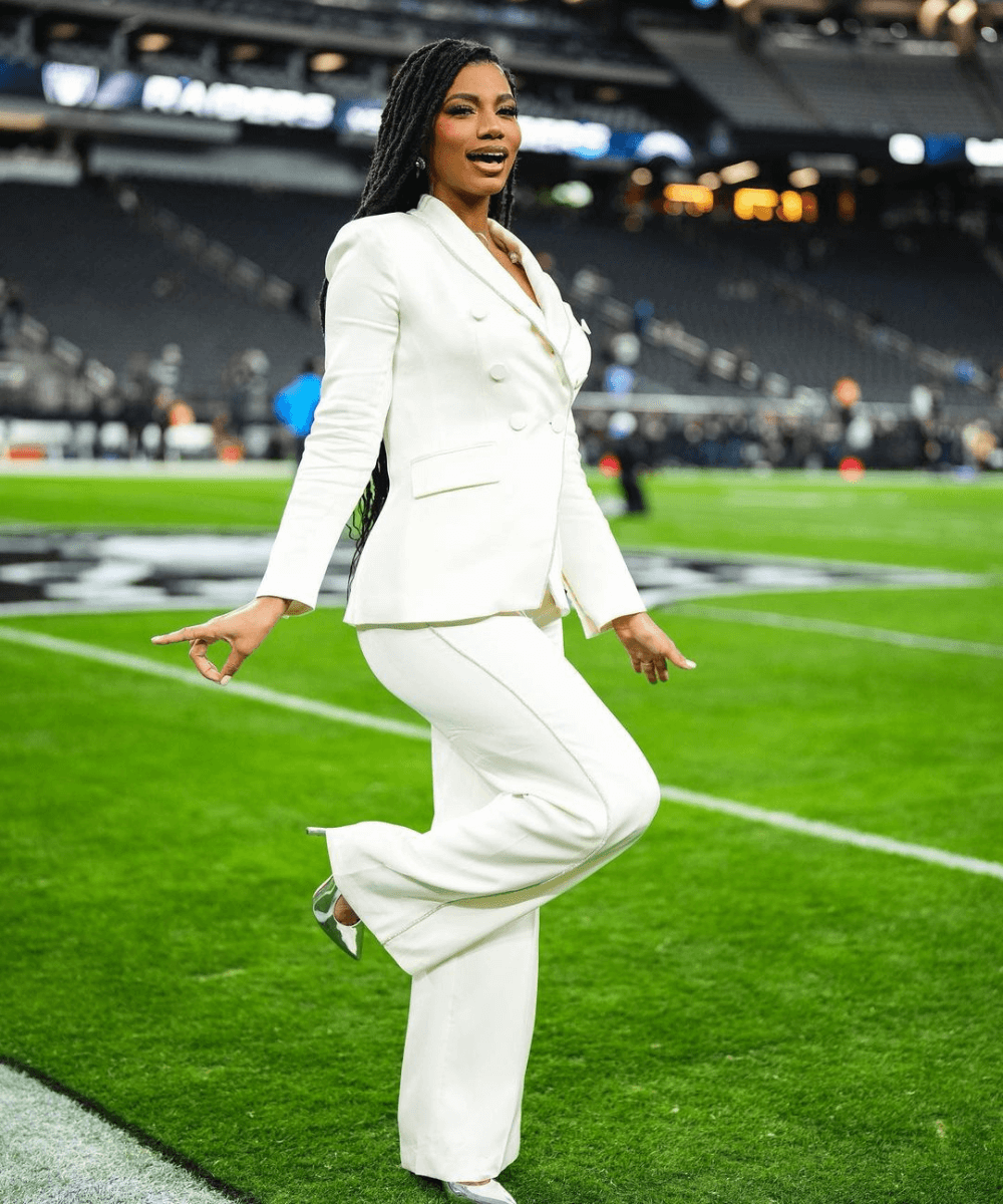 Taylor Rooks - conjunto alfaiataria branco - Taylor Rooks - primavera - mulher negra em pé em um estádio de futebol americano - https://stealthelook.com.br