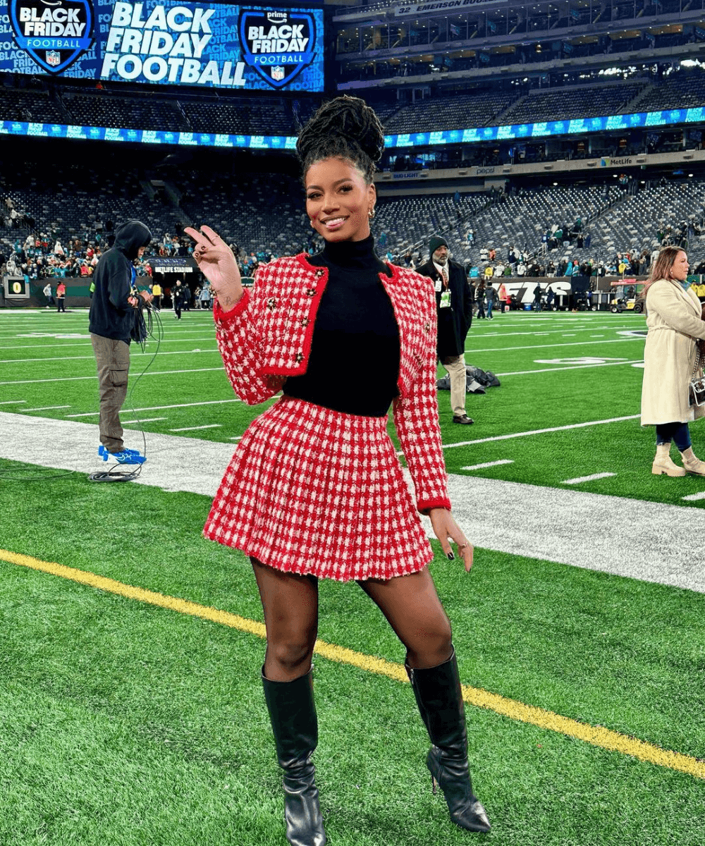 Taylor Rooks - conjunto xadrez rosa e bota de cano longo - Taylor Rooks - outono - mulher negra em pé em um campo de futebol americano - https://stealthelook.com.br