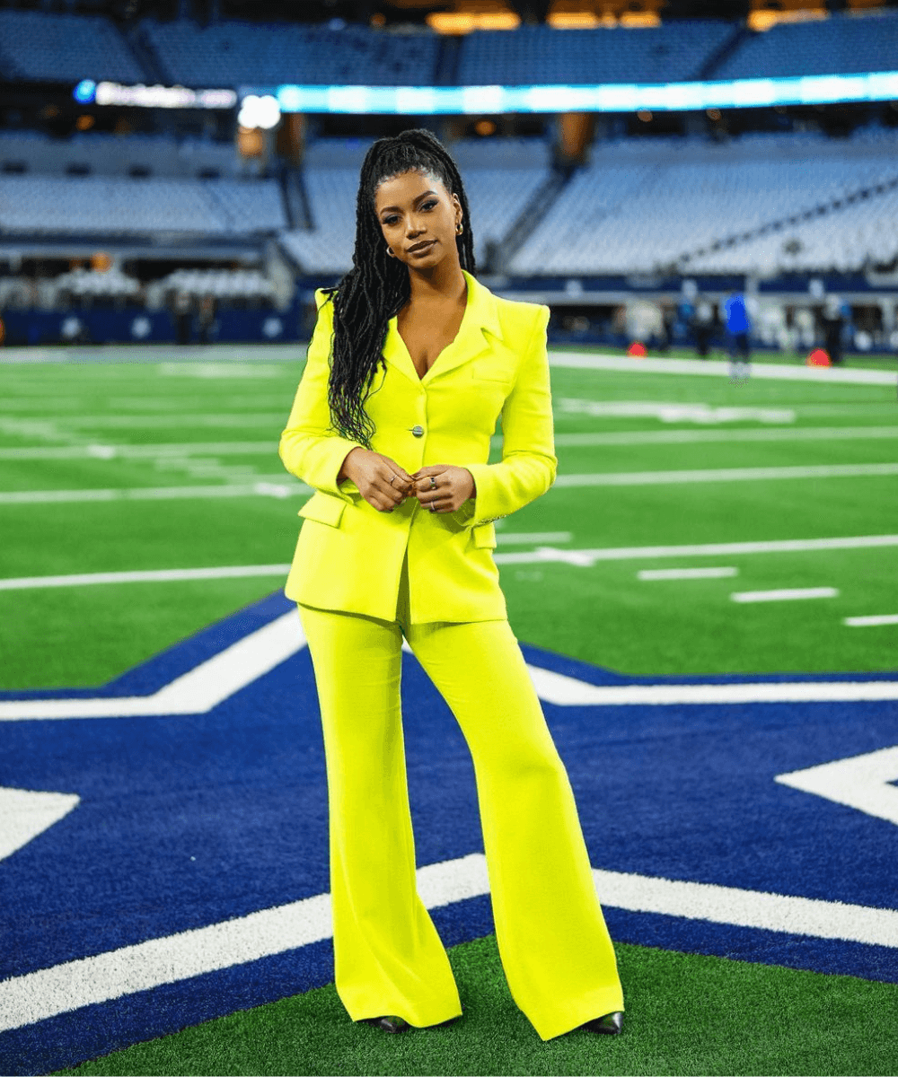 Taylor Rooks - conjunto verde limão de alfaiataria - Taylor Rooks - outono - mulher negra em pé em um campo de futebol americano - https://stealthelook.com.br