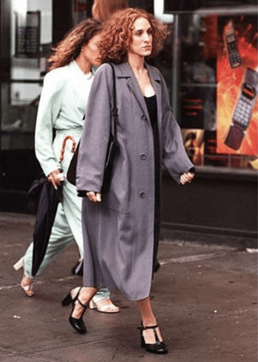 Sarah Jessica Parker - vestido preto, sandália e casaco longo cinza - Carrie Bradshaw - outono - mulher andando na rua - https://stealthelook.com.br