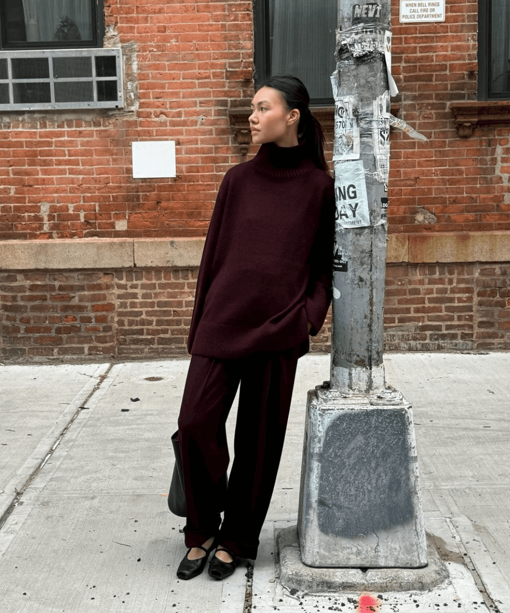 Mimi Nguyen - calça vinho, tricô vinho e sapatilha preta - tricô - inverno - mulher negra em pé na rua encostada em um poste - https://stealthelook.com.br