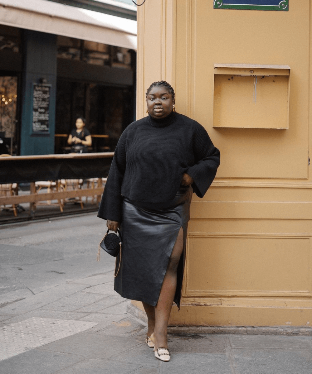 Abisola Omole - saia de couro midi, tricô preto, scarpin preto - tricô - inverno - mulher negra em pé na rua - https://stealthelook.com.br