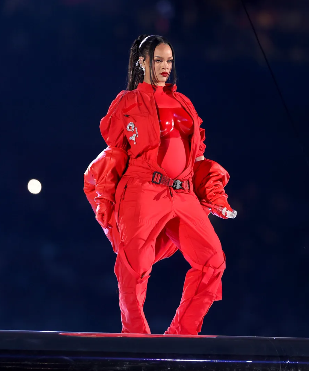 Rihanna - roupa monocromática vermelha - NFL - inverno - Mulher negra grávida em pé - https://stealthelook.com.br