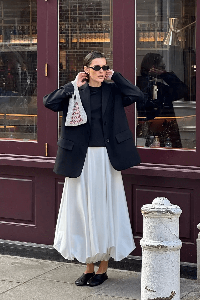 @sobelra - saia midi branca balone, sapatilha, blazer preto  - saia midi branca - outono - mulher em pé na rua usando óculos de sol - https://stealthelook.com.br