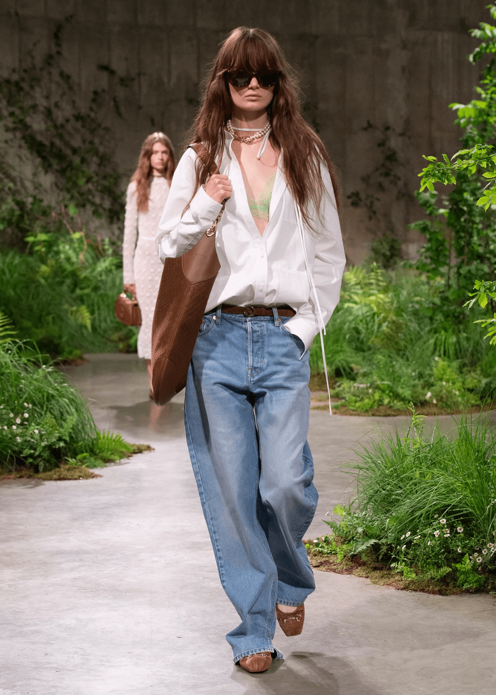 Gucci - calça jeans, camisa branca, sapatilha marrom, bolsa e óculos de sol - sapatilha da gucci - verão - mulher andando na passarela - https://stealthelook.com.br