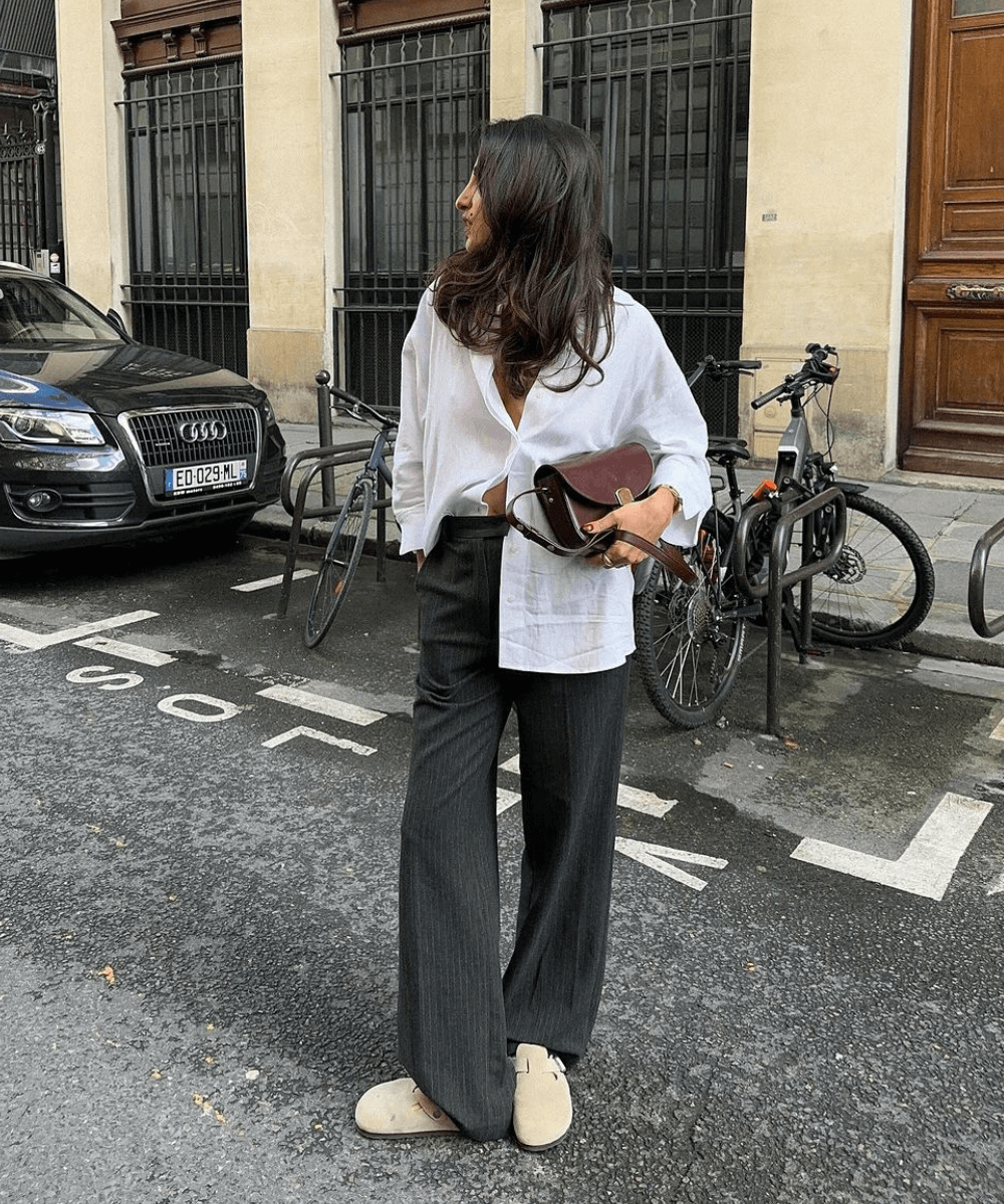 Taïna Cassagnes - calça de alfaiataria, camisa branca e clog - sapato tendência de 2024 - outono - mulher negra em pé na rua usando óculos de sol - https://stealthelook.com.br
