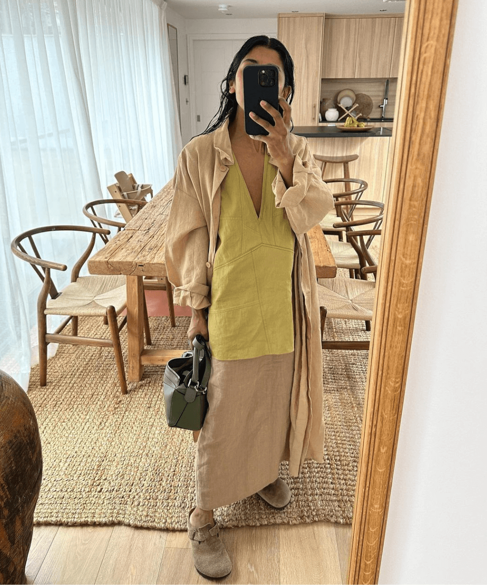 @monikh - saia longa marrom, vestido verde e casaco longo bege - sapato tendência de 2024 - inverno - mulher tirando foto na frente de um espelho - https://stealthelook.com.br