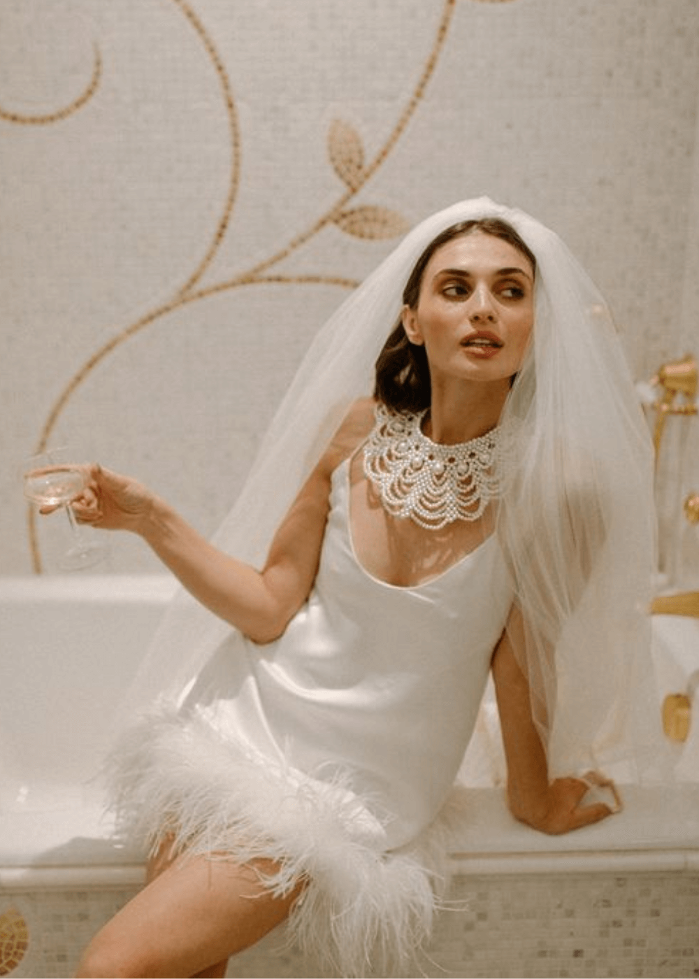 N/A - vestido branco com plumas na barra - vestido de noiva curto - verão - mulher sentada em uma banheira usando um vestido de noiva curto - https://stealthelook.com.br