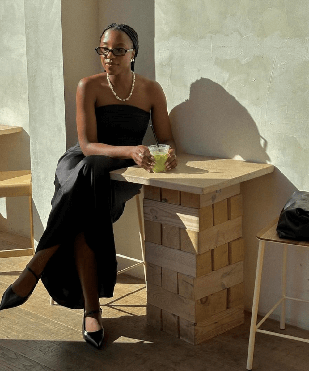 @taffymsipa - vestido preto sem alças, sapatilha e óculos de sol preto - Vestido preto - verão - mulher negra sentada em uma mesa na rua - https://stealthelook.com.br