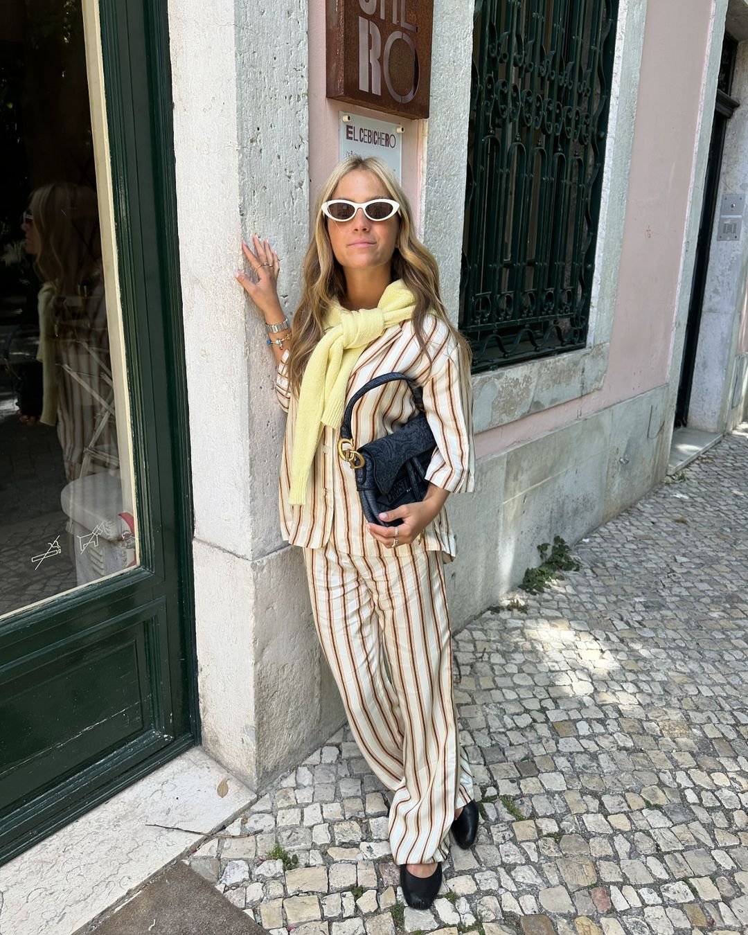 Caetana - conjunto-listrado-calça-listrada-blusa-listrada-quiet-luxury-sueter-manteiga-bolsa-preta-sapatilha - calça listrada - primavera - Lisboa - https://stealthelook.com.br