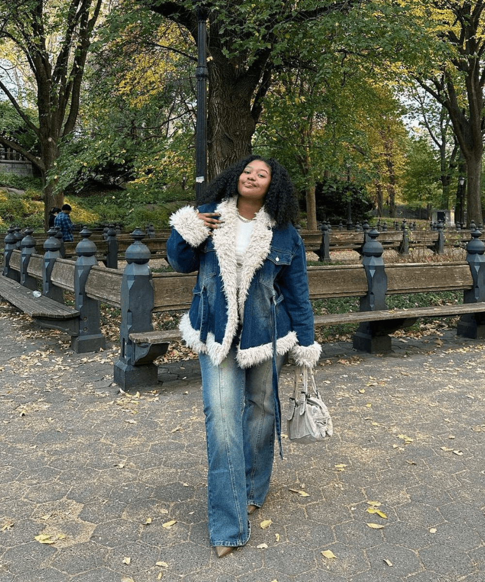 @_dezsmith - calça jeans, jaqueta jeans peluda e botas - looks para festa junina com calça jeans - inverno - mulher negra em pé na rua - https://stealthelook.com.br