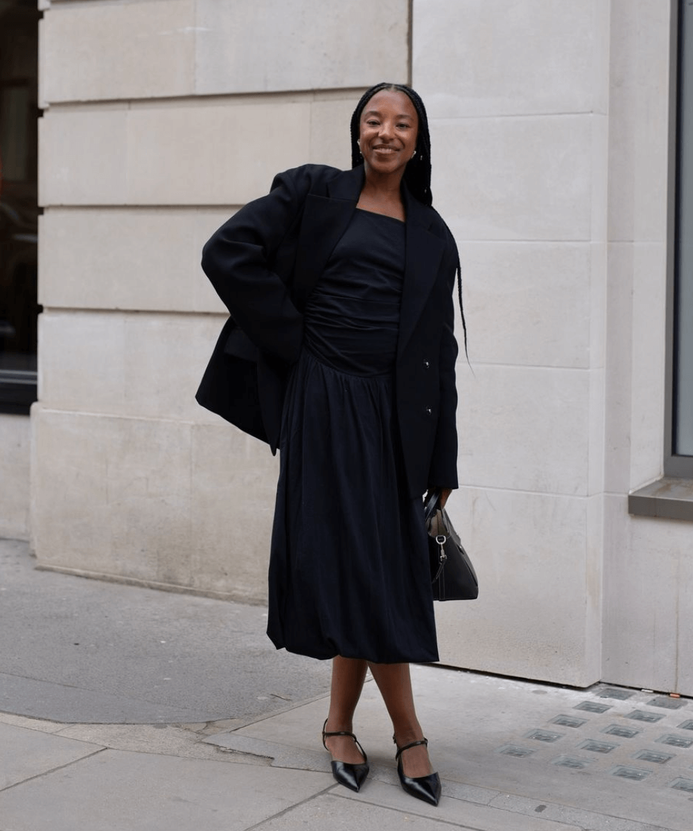 @taffymsipa - vestido midi preto, blazer preto, sapatilhas e bolsa preta - vestido elegante e estiloso - primavera - mulher negra em pé na rua - https://stealthelook.com.br